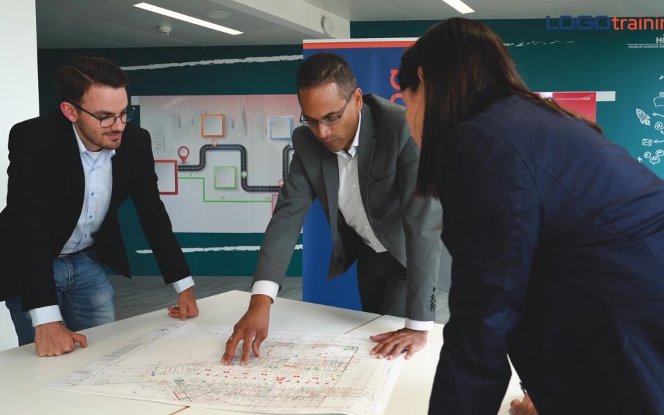 Huascar Rodriguez, Till Eichelbaum und Elvira Büttner besprechen einen Bauplan, der auf einem Tisch liegt