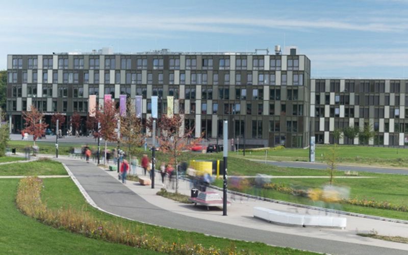 Hochschule Bielefeld mit großer Grünanlage im Vordergrund