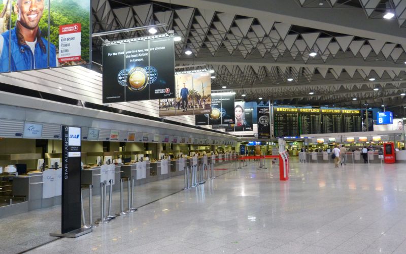 Innenansicht des Terminal 1 des Flughafen Frankfurts mit Werbetafeln