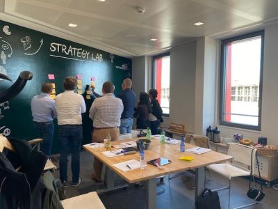 Andreas Klein und weitere Personen vor einer Strategie-Tafel mit Haftnotizen